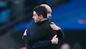 Pelatih Manchester City, Pep Guardiola memeluk pelatih Arsenal, Mikel Arteta, setelah laga final Carabao Cup di Stadion Wembley, Minggu (22/3/2026). (AFP/Glyn Kirk)