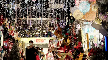 Seorang pria berjalan melewati toko yang menjual dekorasi Natal di sebuah pasar di Taipei, Taiwan (8/12/2021). Jelang Natal, warga Taipe yang merayakannya mulai berburu dekorasi dan pernak-pernik, dengan tujuan mempercantik rumah mereka saat perayaan 25 Desember 2021. mendatang. (AFP/Sam Yeh)