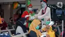 Petugas KAI yang mengenakan kostum Natal membagikan masker kepada calon penumpang di Stasiun Senen, Jakarta, Jumat (25/12/2020). Pembagian ini juga untuk memutus mata rantai penyebaran COVID-19 saat mudik Natal dan Tahun Baru 2021. (merdeka.com/Imam Buhori)