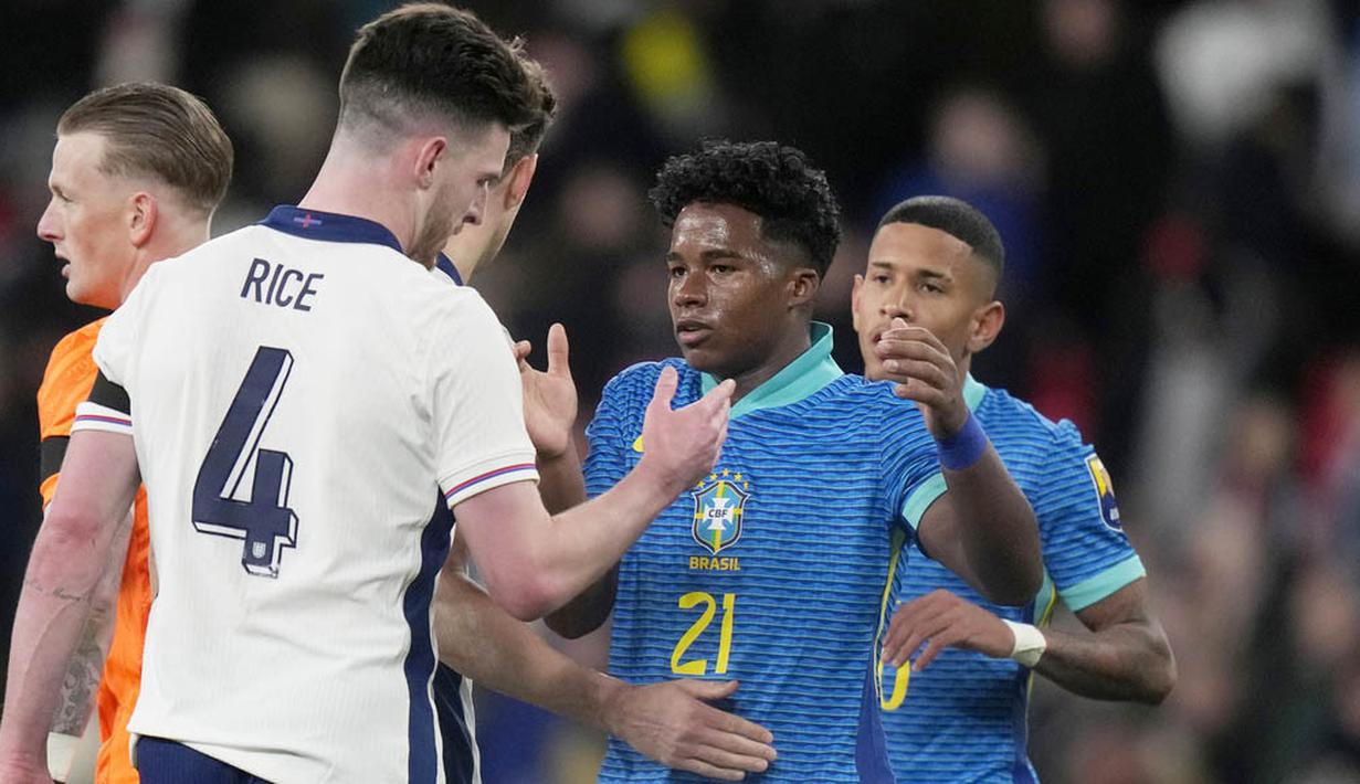 Pemain Brasil, Endrick, besalaman dengan pemain Inggris, Declan Rice, dalam laga persahabatan di Stadion Wembley, Minggu (24/3/2024). (AP Photo/Alastair Grant)