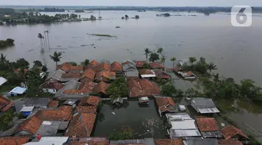 Foto udara suasana pemukiman warga yang terendam banjir menggunakan kamera nir-awak di Desa Karangligar dan Dusun Pengasinan kecamatan Teluk Jambe Barat, Kabupaten Karawang, Selasa (6/12/2022).  Banjir yang terjadi setelah hujan deras yang mengguyur sejak Minggu (4/12/2022) mulai berangsur surut. (merdeka.com/Imam Buhori)