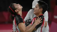 Ganda putri Indonesia Apriyani Rahayu dan Greysia Polii berselebrasi setelah menang atas pasangan China pada final badminton ganda putri Olimpiade Tokyo 2020 di Musashino Forest Sport, Senin (2/8/2021). (Alexander NEMENOV/AFP)