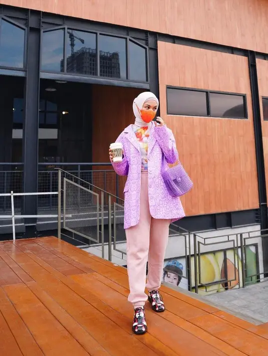 Tampil eksentrik dengan padu padan blazer dan inner warna terang, serta jogger pants warna pink. Kece abis! (Instagram/tantrinamirah).