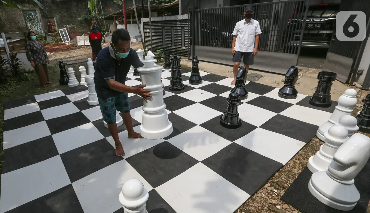 Warga bermain catur raksasa sambil menunggu waktu berbuka puasa di Pondok Betung, Tangerang Selatan, Kamis (14/5/2020). Catur berukuran raksasa dengan luas lapangan 4,8m x 4,8m dilakukan warga untuk mengisi kegiatan selama Pembatasan Sosial Berskala Besar (PSBB). (Liputan6.com/Fery Pradolo)
