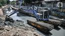 Petugas Sudin SDA Jakarta Pusat menggunakan alat berat saat pengerukan lumpur di Kali Sentiong, Kecamatan Johar Baru, Rabu (22/9/2021). Pengerukan lumpur Kali Sentiong sekaligus mencegah banjir di kawasan tersebut yang kerap terjadi saat musim hujan. (merdeka.com/Iqbal S. Nugroho)