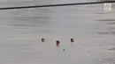 Anak-anak berenang di Sungai Ciliwung yang meluap di kawasan Rawajati, Jakarta, Jumat (26/4). Tingginya volume debit air yang berasal dari Bogor tidak menyurutkan niat anak-anak itu untuk tetap berenang, meskipun berbahaya bagi keselamatan. (Liputan6.com/Immanuel Antonius)