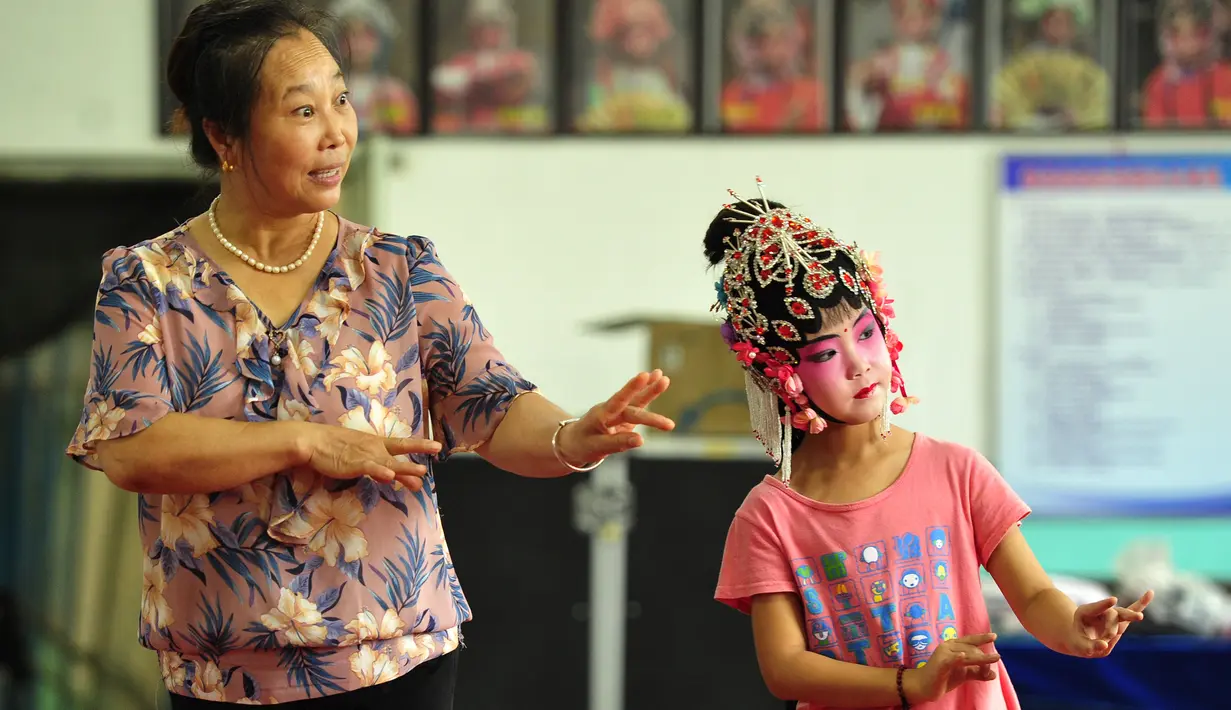 Seorang anak mempelajari Opera Hahaqiang dari seorang guru di Mumendian, Qingxian, Provinsi Hebei, China, 27 Agustus 2020. Beberapa anak menghabiskan liburan musim panas mereka dengan mempelajari Opera Hahaqiang, sebuah opera lokal di beberapa bagian Provinsi Hebei dan Shandong.(Xinhua/Mu Yu)