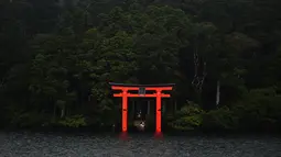 Torii (gerbang merah) dari kuil Hakone-Jinja terlihat di Danau Ashi di prefektur Kanagawa, Jepang (11/9/2019). Nama Danau Ashi atau yang dikenal juga dengan Danau Ashinoko ini dalam bahasa Jepang memiliki arti lautan alang-alang. (AFP Photo/Charly Triballeau)