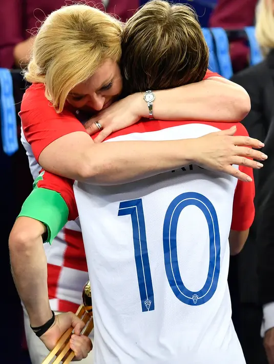 Presiden Kroasia, Kolinda Grabar-Kitarovic memeluk Kapten timnas Kroasia, Luka Modric pada akhir laga final Piala Dunia 2018 di Luzhniki Stadium, Minggu (15/7). Kroasia harus puas menjadi runner-up seusai kalah 2-4 melawan Prancis. (AP/Martin Meissner)
