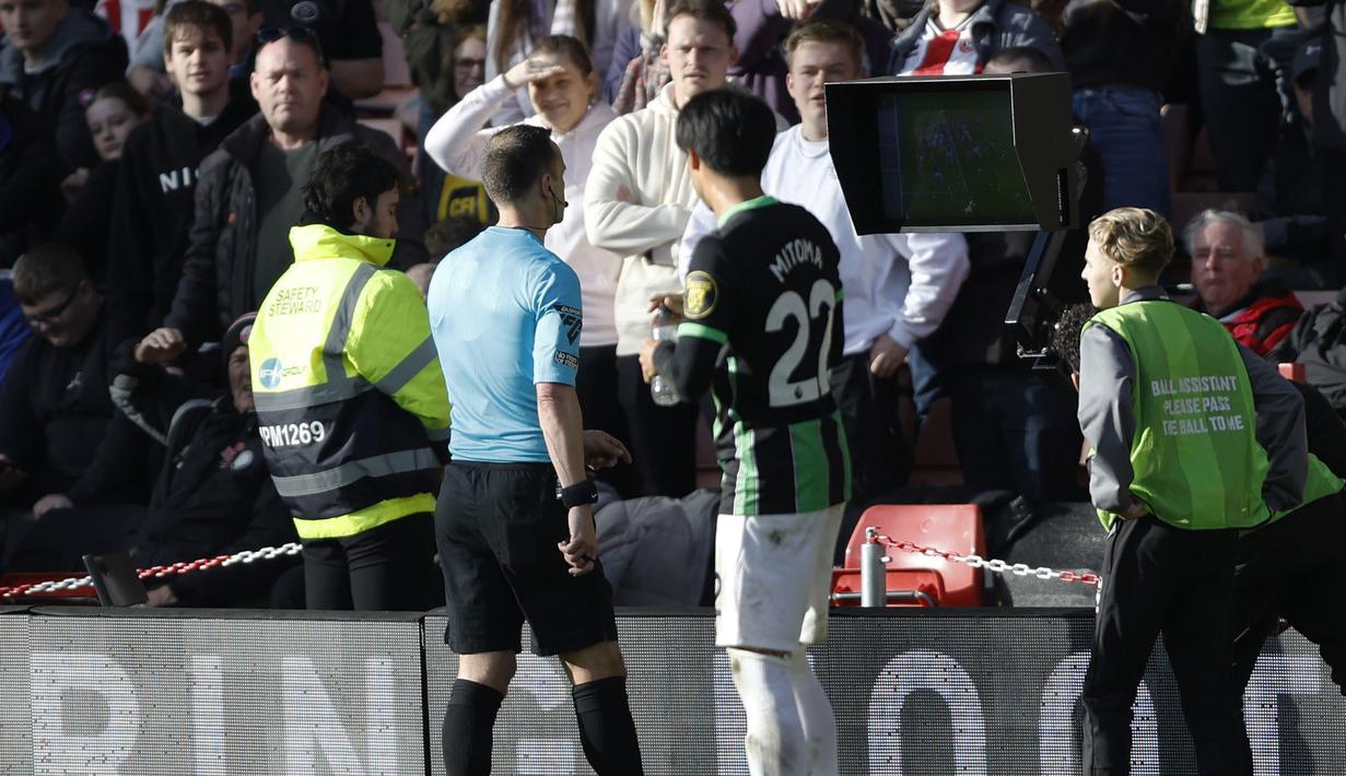 <p>Wasit Stuart Attwell meninjau VAR untuk memutuskan pelanggaran pemain Sheffield United, Mason Holgate terhadap pemain Brighton, Kaoru Mitoma pada laga lanjutan Liga Inggris 2023/2024 di Bramall Lane stadium, Sheffield, Inggris, Minggu (19/02/2024). (AP Photo/PA/Nick Potts)</p>