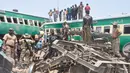 Tim penyelamat dan penduduk setempat berkumpul di dekat kecelakaan yang terjadi antara dua kereta di distrik Rahim Yar Khan, Pakistan, Kamis (11/7/2019). Insiden ini menyebabkan setidaknya sembilan orang tewas dan lebih dari 60 lainnya luka-luka. (AP Photo/Waleed Saddique)