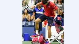 Petenis Serbia, Novak Djokovic, menginjak raketnya saat bertanding melawan petenis Spanyol,  Roberto Bautista Agut dalam Turnamen Tenis AS Terbuka 2015 di USTA Billie Jean King National Tennis Center, New Yok, AS. (AFP Photo/Don Emmert)
