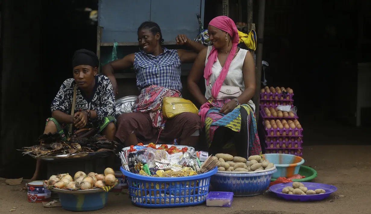 Perempuan menjual bawang dan kentang di pasar Kaporo di Conakry, Guinea, Senin (13/9/2021). Pasukan elit militer Guinea melakukan kudeta dan menangkap Presiden Alpha Conde pada Minggu, 5 September lalu. (AP Photo/ Sunday Alamba)
