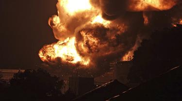 Api melalap kilang minyak milik Pertamina, di Cilacap, Jawa Tengah, Minggu dini hari (14/11/2021). Tangki kilang Pertamina terbakar pada Sabtu 13 November 2021 pukul 19.10 WIB. (AP Photo/Agus Fitrah)