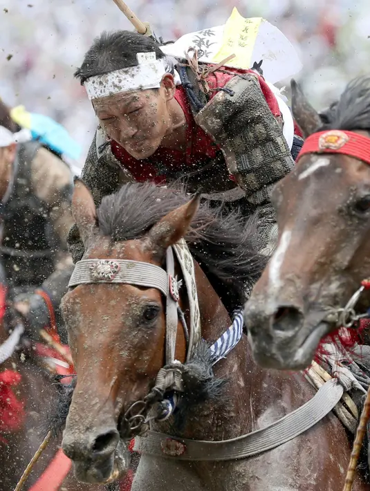 Ekspresi peserta saat mamacu kudanya dalam balap Armor Horse Racing di festival Soma Nomaoi di Minamisoma (30/7). Balapan ini diikuti oleh 12 penunggang kuda dengan jarak lomba 1.000 meter. (Jun Hirata/Kyodo News via AP)
