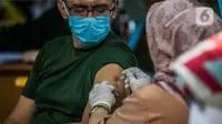 Seorang pria mendapatkan vaksinasi dosis ketiga (booster) di Taman Suropati, Jakarta, Selasa (5/7/2022). Aturan vaksin booster sebagai syarat baru perjalanan bagi masyarakat diperkirakan akan mulai berlaku 2 pekan dari sekarang. (Liputan6.com/Faizal Fanani)