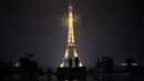 Pengunjung berkumpul di alun-alun Trocadero sebelum lampu Menara Eiffel dipadamkan di Paris, Senin (2/10). Lampu di menara yang menjadi ikon Negara Prancis ini akan dimatikan sebagai penghormatan kepada korban penembakan di Las Vegas. (AP/Kamil Zihnioglu)