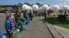 Warga Lebanon menunggu untuk mengisi tabung gas di kota selatan Sidon, Selasa (10/8/2021). Warga Lebanon harus mengantre panjang demi membeli gas untuk memasak di tengah krisis ekonomi parah yang memicu kelangkaan berbagai kebutuhan pokok dari obat-obatan hingga bahan bakar. (Mahmoud ZAYYAT/AFP)