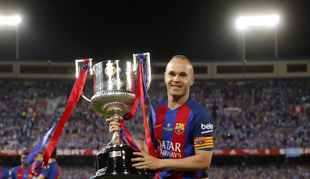 Andres Iniesta memegang trofi Piala Raja Spanyol (Copa del Rey) di stadion Vicente Calderon, Spanyol, Minggu (28/5). Barcelona sukses mempertajam rekornya di kancah Copa del Rey dengan keberhasilan menjadi juara sebanyak 29 kali. (AP Photo)