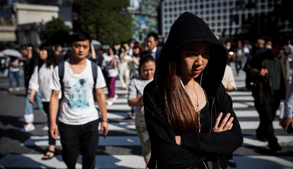 Pejalan kaki berjalan melintasi persimpangan Shibuya di Tokyo, Jepang (23/5/2019). Shibuya adalah salah satu distrik khusus kota Tokyo, Jepang. Distrik kota ini didirikan pada 15 Maret 1947. (AFP Photo/Behrouz Mehri)