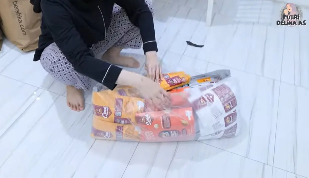 Melalui kanal Youtubenya, Putri Delina membagikan beberapa persiapan jelang keberangkatannya. Selain pakaian, juga tak ketinggalan makanan Indonesia. [Youtube/Putri Delina AS]