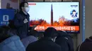 Orang-orang menonton TV yang menampilkan file gambar peluncuran rudal Korea Utara selama program berita di Stasiun Kereta Api Seoul di Seoul, Korea Selatan, Selasa (11/1/2022). Korea Utara disebut menembakkan proyektil yang diduga mirip rudal balistik ke laut. (AP Photo/Ahn Young-joon)