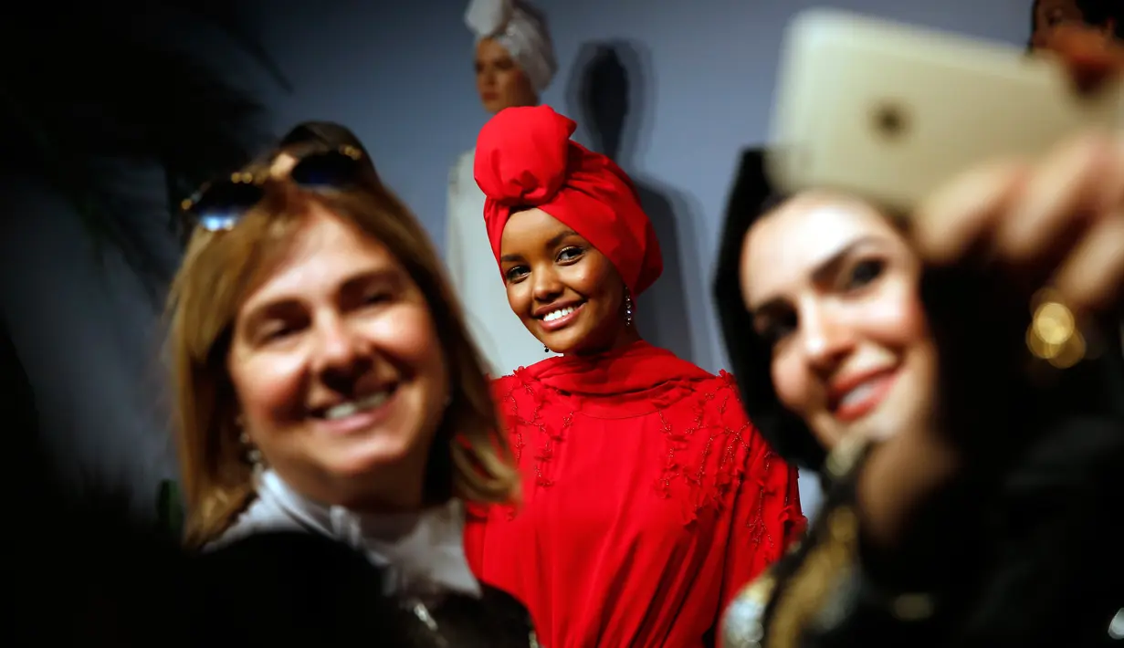 Penggiat dunai fashion berfoto dengan Halima Aden saat peragaan busana di Istanbul, Turki (26/3). Di balik kesuksesannya sekarang ini, Halima Aden dulu merupakan seorang pengungsi asal Somalia. (AP Photo / Lefteris Pitarakis)