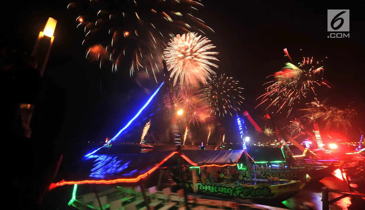 Pengunjung menyaksikan pesta kembang api saat malam Tahun Baru 2019 di Pantai Lagoon, Ancol, Jakarta, Selasa (1/1). Ancol menyajikan pesta kembang api musikal sepanjang 600 meter di bibir pantai dalam menyambut Tahun Baru 2019. (Merdeka.com/Iqbal Nugoho)