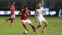 Pemain Timnas Indonesia U-23, Evan Dimas (kiri) mengecoh pemain Suriah U-23, Ahmad Al Ahmad pada laga persahabatan di Stadion Wibawa Mukti, Bekasi, Rabu (16/11/2017). Indonesia kalah 2-3. (Bola.com/NIcklas Hanoatubun)