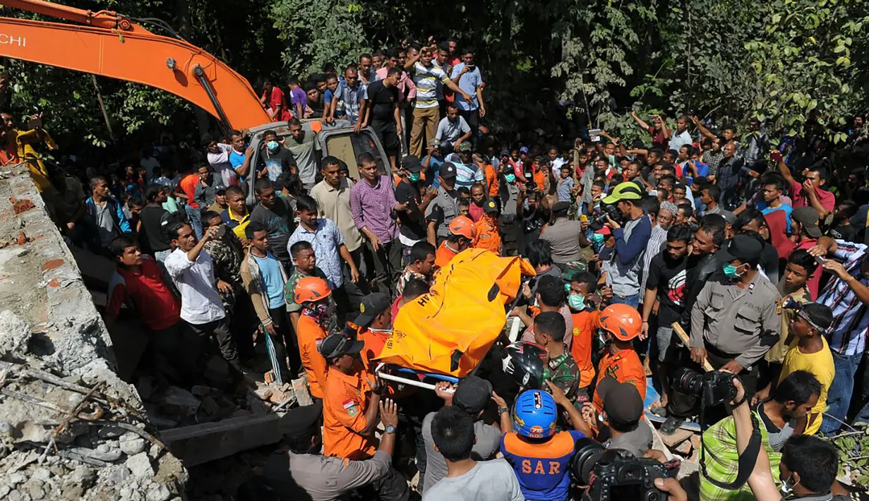 Petugas gabungan membawa kantong jenazah korban  menyusul gempa 6,4 SR di Kabupaten Pidie Jaya, Aceh, Rabu (7/12). Rata-rata korban gempa tinggal di rumah toko di beberapa titik di Pidie Jaya. (AFP PHOTO/Chaideer Mahyuddin)