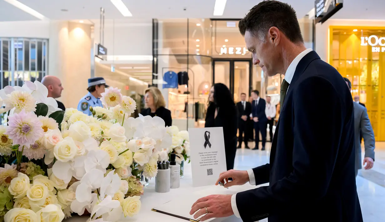 Perdana Menteri New South Wales Chris Minns menandatangani buku duka cita saat memberikan penghormaatan untuk para korban yang kehilangan nyawa mereka dalam serangan pisau di pusat perbelanjaan Westfield Bondi Junction di Sydney, Kamis (18/4/2024). (BIANCA DE MARCHI / POOL / AFP)