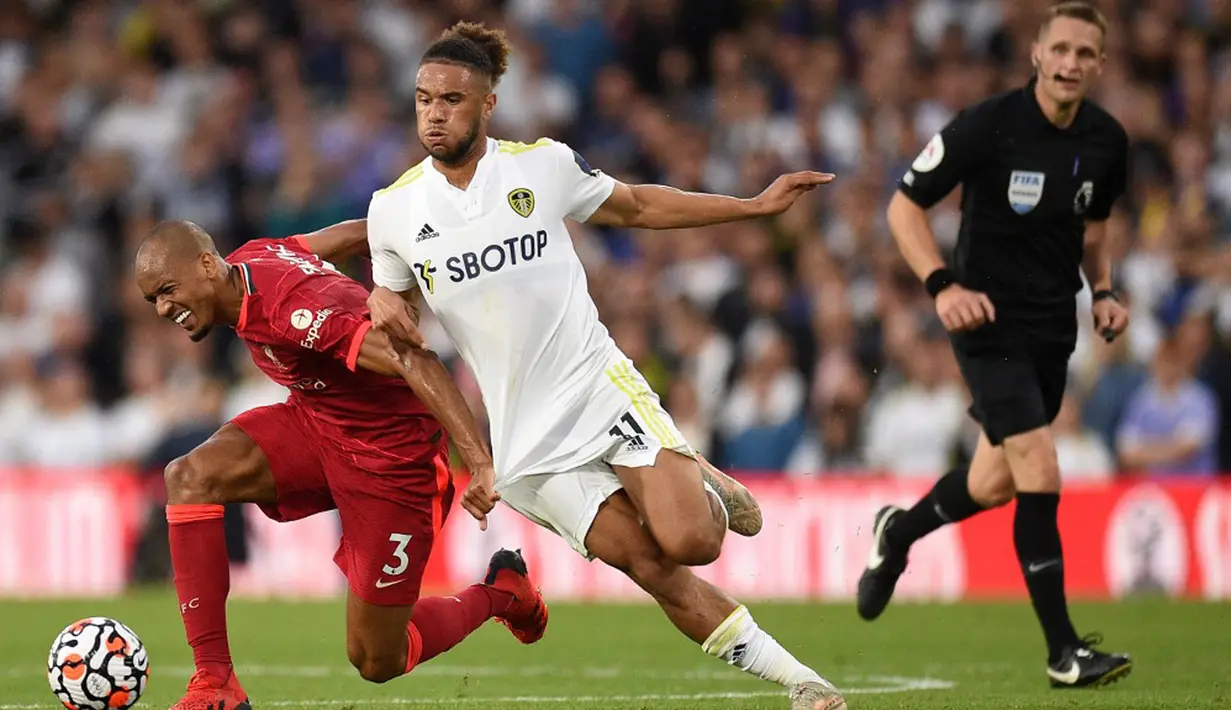 Pemain Liverpool Fabinho (kiri) berebut bola dengan pemain Leeds United Tyler Roberts (tengah) pada pertandingan Liga Inggris di Elland Road, Leeds, Inggris, 12 September 2021.  Liverpool menang 3-0. (Oli SCARFF/AFP)
