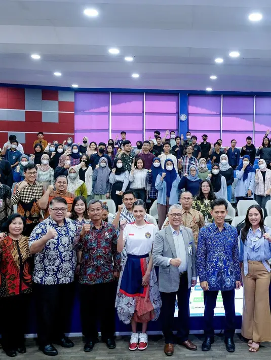 Kali ini, ia tampil dengan casual sporty look. Mikha memadukan jersey Menpora-nya dengan rok balon batik dan sepatu kets nuansa biru dan merah.