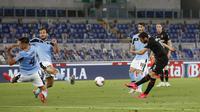 Pemain AC Milan Hakan Calhanoglu (kanan) mencetak gol ke gawang Lazio pada pertandingan Serie A di Olympic Stadium, Roma, Italia, Sabtu (4/7/2020). AC Milan mengalahkan Lazio dengan skor 3-0. (AP Photo/Riccardo De Luca)