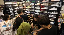 Pengunjung memilih berbagai macam sepatu yang ada pada pameran sneaker dan streetwear berskala internasional Jakarta Sneaker Day (JSD) di ICE BSD City, Tangerang, Banten, Sabtu (25/2/2023). Ada nama-nama besar yang sudah tak asing lagi seperti Atmos, Asics, Bratpack, CAT Footwear, Etaks, FILA, KEEN, New Balance, Our Daily Dose, PUMA, SEEK Indonesia, dan VAST. (Liputan6.com/Johan Tallo)