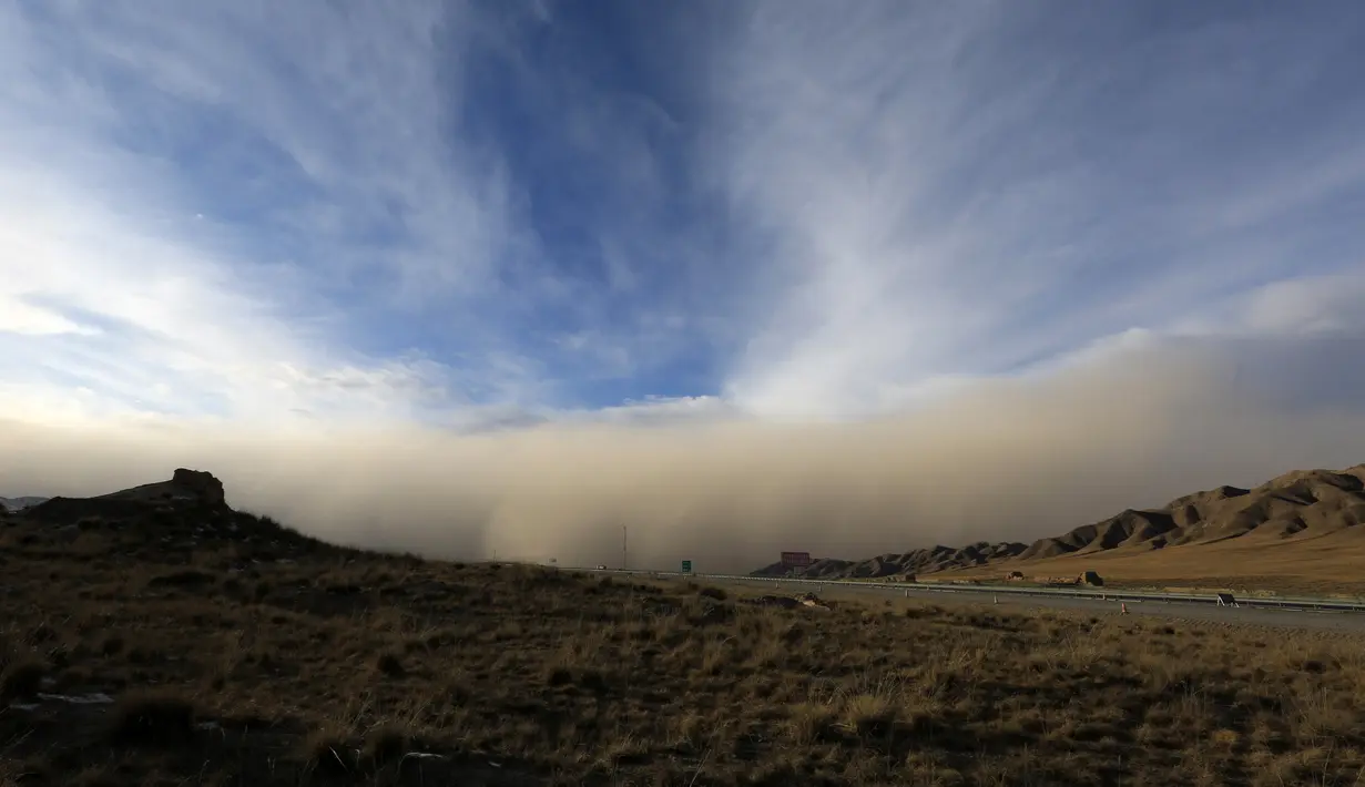 Badai pasir bergerak ke Zhangye di provinsi Gansu barat laut China (25/11). Menurut pemerintah setempat, sebuah kota di barat laut China ini dilanda badai pasir yang memicu kebakaran di pedesaan.  (AFP Photo/China Out)