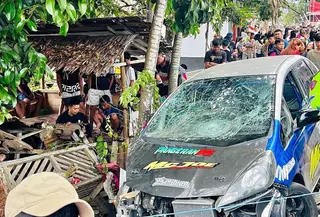 Penampakan mobil yang menghantam sejumlah penonton dan keluar dari area balap di ajang drag race di Kelurahan Upai, Kecamatan Kotamobagu Utara, Kota Kotamobagu, Sulawesi Utara. (Liputan6/Yoseph Ikanubun)