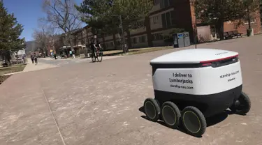 Sebuah robot pengantar makanan melintasi kampus Northern Arizona University di Flagstaff, Arizona, Amerika Serikat, Selasa (26/3). Ada lusinan robot pengantar makanan di kampus ini. (Ben Shanahan/Arizona Daily Sun via AP)