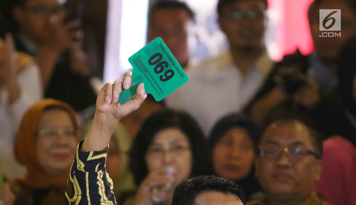Peserta lelang mengangkat tanda keanggotaan dalam 110 Tahun Lelang Indonesia di Galeri Nasional, Jakarta, Rabu (28/2). Mayoritas koleksi barang tidak mewah, namun memiliki kenangan tersendiri bagi pemiliknya. (Liputan6.com/Angga Yuniar)
