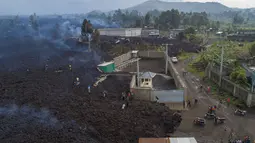 Warga melihat lava dari letusan Gunung Nyiragongo membelah Buhene di utara Goma, Kongo (24/5/2021). Gunung Nyiragongo mengirimkan aliran lahar ke desa-desa smenyebabkan sedikitnya 15 orang tewas di tengah kekacauan dan menghancurkan lebih dari 500 rumah. (AP Photo/Justin Kabumba)