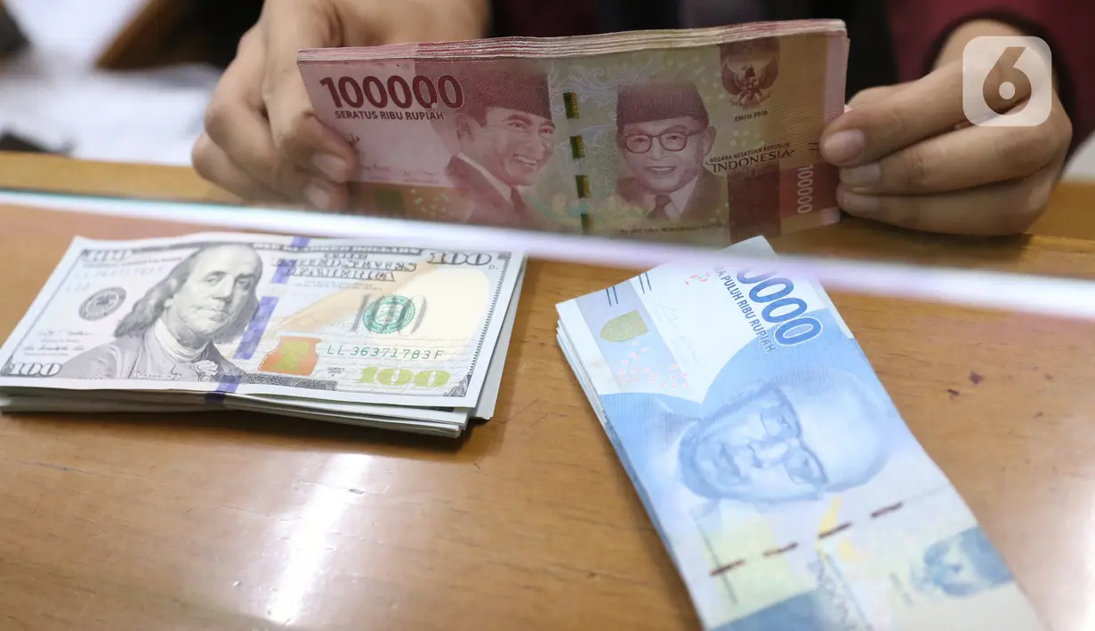 Petugas menunjukkan mata uang rupiah dan dolar di Jakarta, Senin (9/11/2020). Menjelang siang, rupiah terus menguat ke level 14.145 per dolar AS. (Liputan6.com/Angga Yuniar)