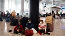 Penumpang yang terdampar menunggu di bandara Istanbul, di mana penerbangan dibatalkan karena badai salju dan hujan salju lebat, di Istanbul, Turki, pada 25 Januari 2022. Bandara Istanbul menunda pengoperasian kembali karena kondisi cuaca buruk yang menghambat operasional. (Yasin AKGUL/AFP)