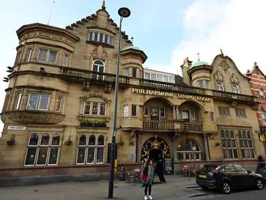 Pejalan kaki berjalan melewati pub Philharmonic Dining Rooms di Liverpool, Inggris pada 11 Februari 2020. Tempat nongkrong favorit anggota The Beatles ini mendapat status cagar budaya Grade I dari pemerintah Inggris. (Paul ELLIS / AFP)