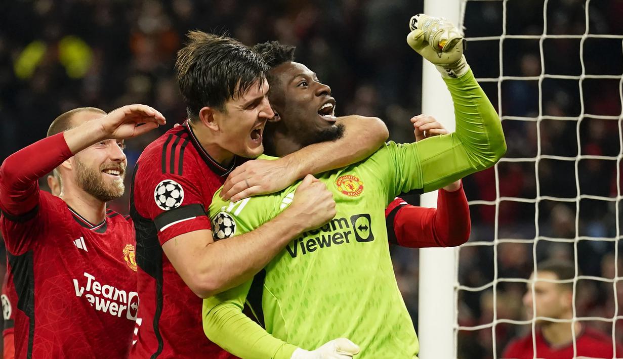 Selebrasi Kiper Manchester United, Andre Onana bersama rekannya, Harry Maguire setelah mementahkan eksekusi penalti striker  FC Copenhagen, Jordan Larsson pada laga matchday ketiga Grup A Liga Champions 2023/2024 di Old Trafford Stadium, Rabu (25/10/2023) dini hari WIB. (AP Photo/Dave Thompson)
