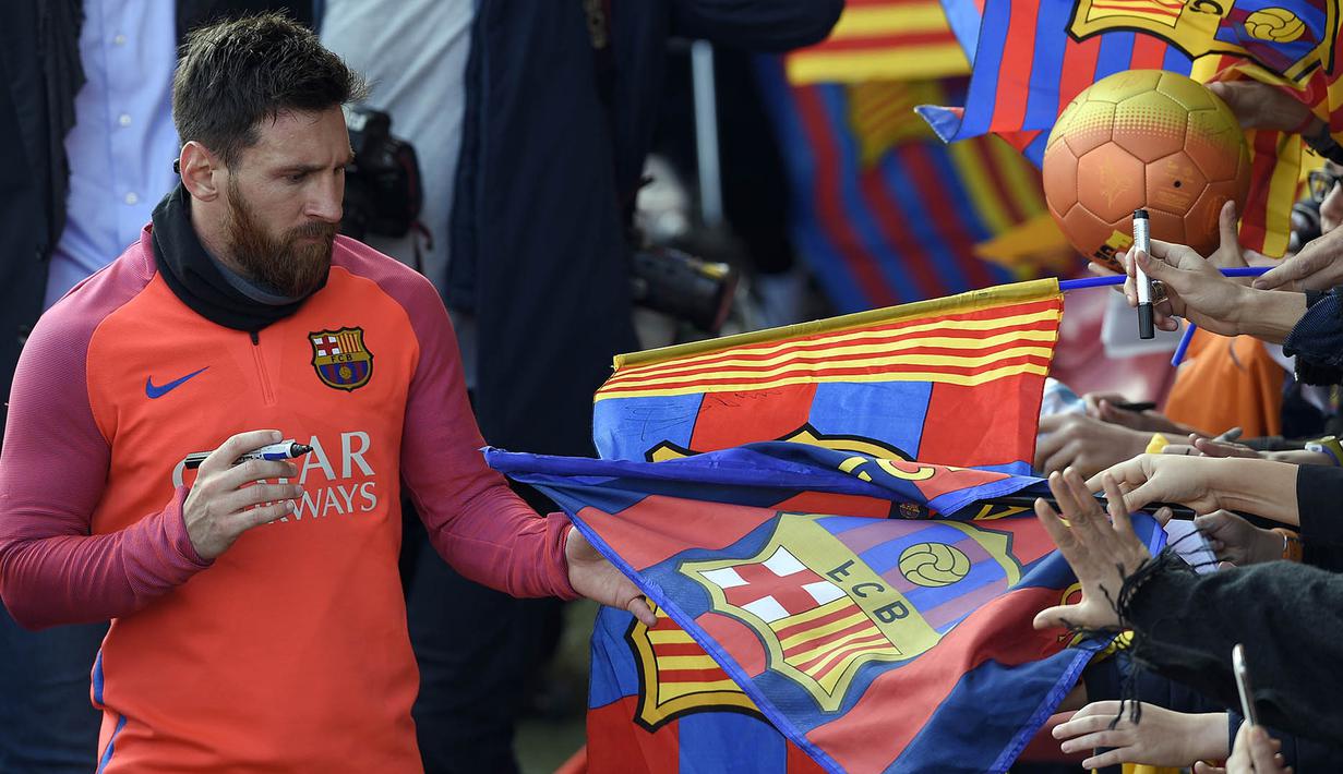Bintang Barcelona, Lionel Messi, memberikan tanda tangan kepada fans usai mengikuti sesi latihan perdana tahun 2017. Selain La Liga, Barca juga masih berjuang untuk trofi Liga Champions tahun ini. (AFP/Lluis Gene)