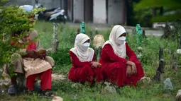 Orang-orang berdoa di sebelah makam kerabat saat perayaan Hari Raya Idul Adha di sebuah pemakaman di Provinsi Narathiwat, Thailand, Rabu (21/7/2021). Setiap Idul Adha atau hari besar Islam lainnya, sebagian warga banyak mendatangi kuburan untuk mendoakan keluarganya. (Madaree TOHLALA/AFP)