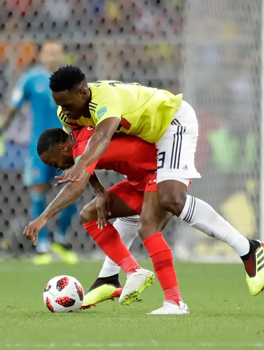 Pemain timnas Inggris, Raheem Sterling berebut bola dengan bek Kolombia, Yerry Mina pada babak 16 besar Piala Dunia 2018 di Stadion Spartak, Selasa (3/7). Sterling menjadi bahan pembicaraan setelah tertangkap kamera menggendong Mina (AP/Matthias Schrader)