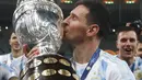 Penyerang  Argentina, Lionel Messi mencium trofi setelah mengalahkan Brasil 1-0 dalam pertandingan sepak bola final Copa America di stadion Maracana di Rio de Janeiro, Brasil, Minggu (11/7/2021). Kemenangan di final ini sangat bersejarah bagi Lionel Messi. (AP Photo/Bruna Prado)