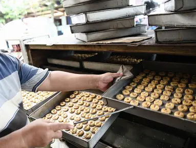  Pekerja menyelesaikan produksi kue kering di Industri kue rumahan Kwitang Pusaka, Jakarta, Selasa (21/6). Jelang lebaran permintaan kue kering industri rumahan meningkat. (Liputan6.com/Faizal Fanani)