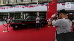 Pengunjung berfoto dengan salah satu mobil kepresidenan yang dipamerkan di Gedung Sarinah, Jakarta Pusat, Kamis (18/8/2022). Pameran dalam rangka Hari Ulang Tahun ke-77 Kemerdekaan Republik Indonesia ini digelar hingga 22 Agustus mendatang dan memamerkan mobil kepresidenan dari Era Presiden Soekarno hingga Presiden Joko Widodo. (Liputan6.com/Johan Tallo)